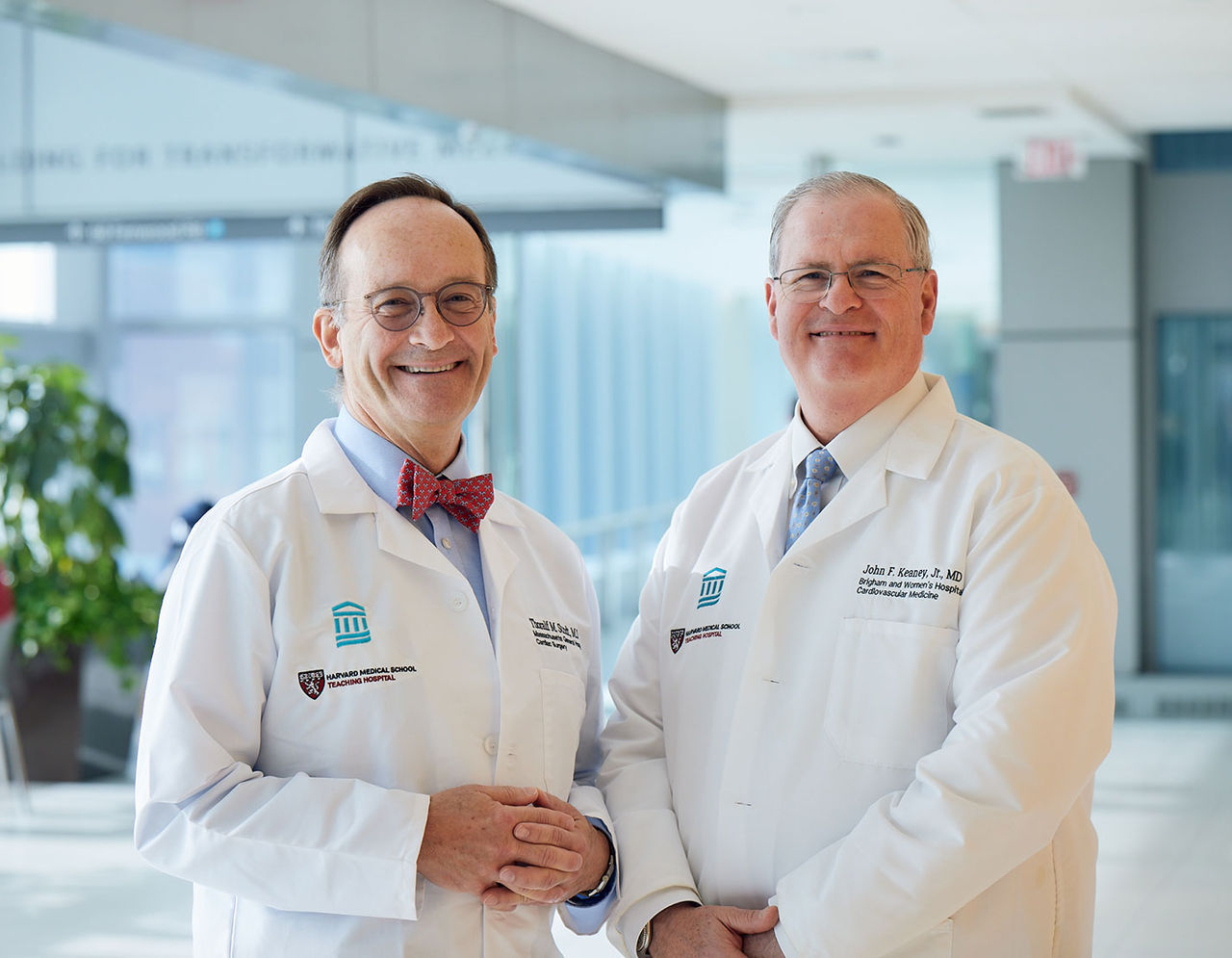 two male heart providers standing in hallway smiling