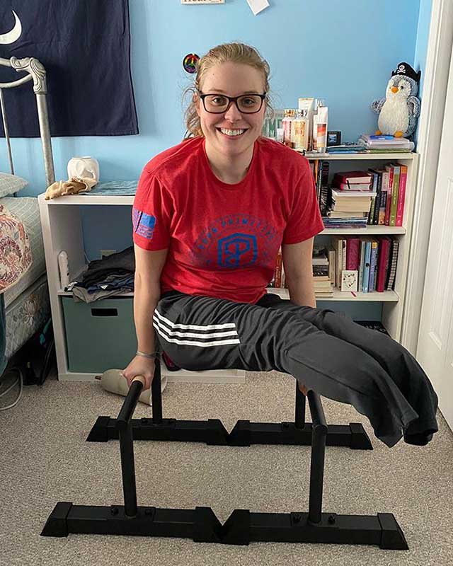 Morgan grins as she balances on double beams in her bedroom, not wearing her prosthetics.