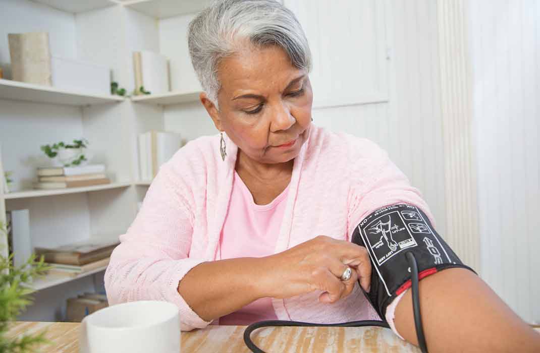 woman using a blood pressure monitor at home