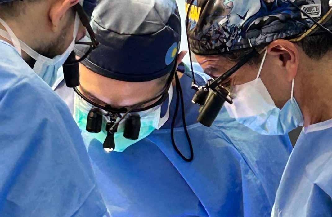 Three physicians in an operating room performing surgery