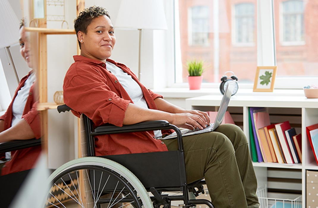 woman in wheelchair using laptop