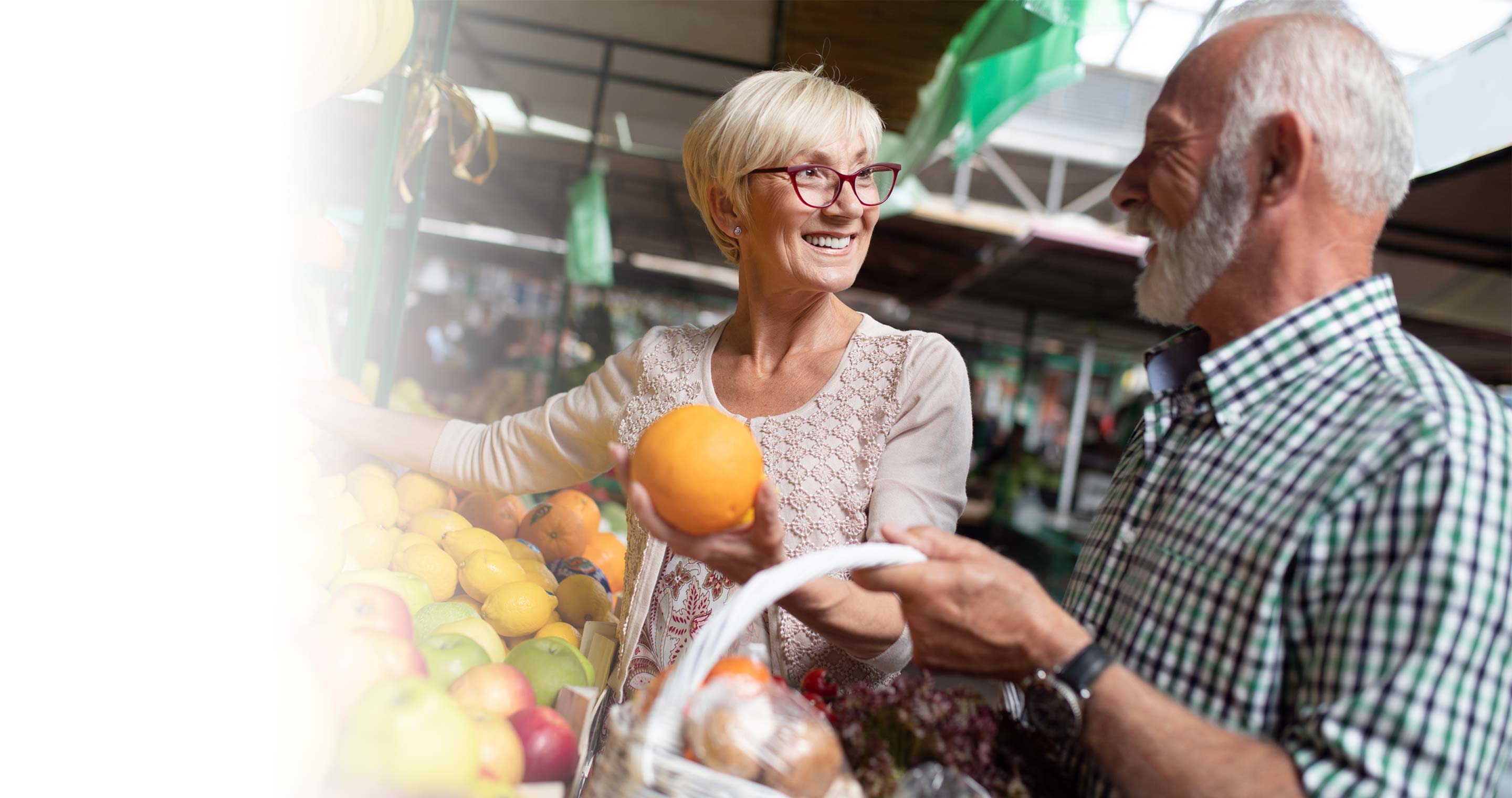 Senior couple shopping for fresh fruit at market