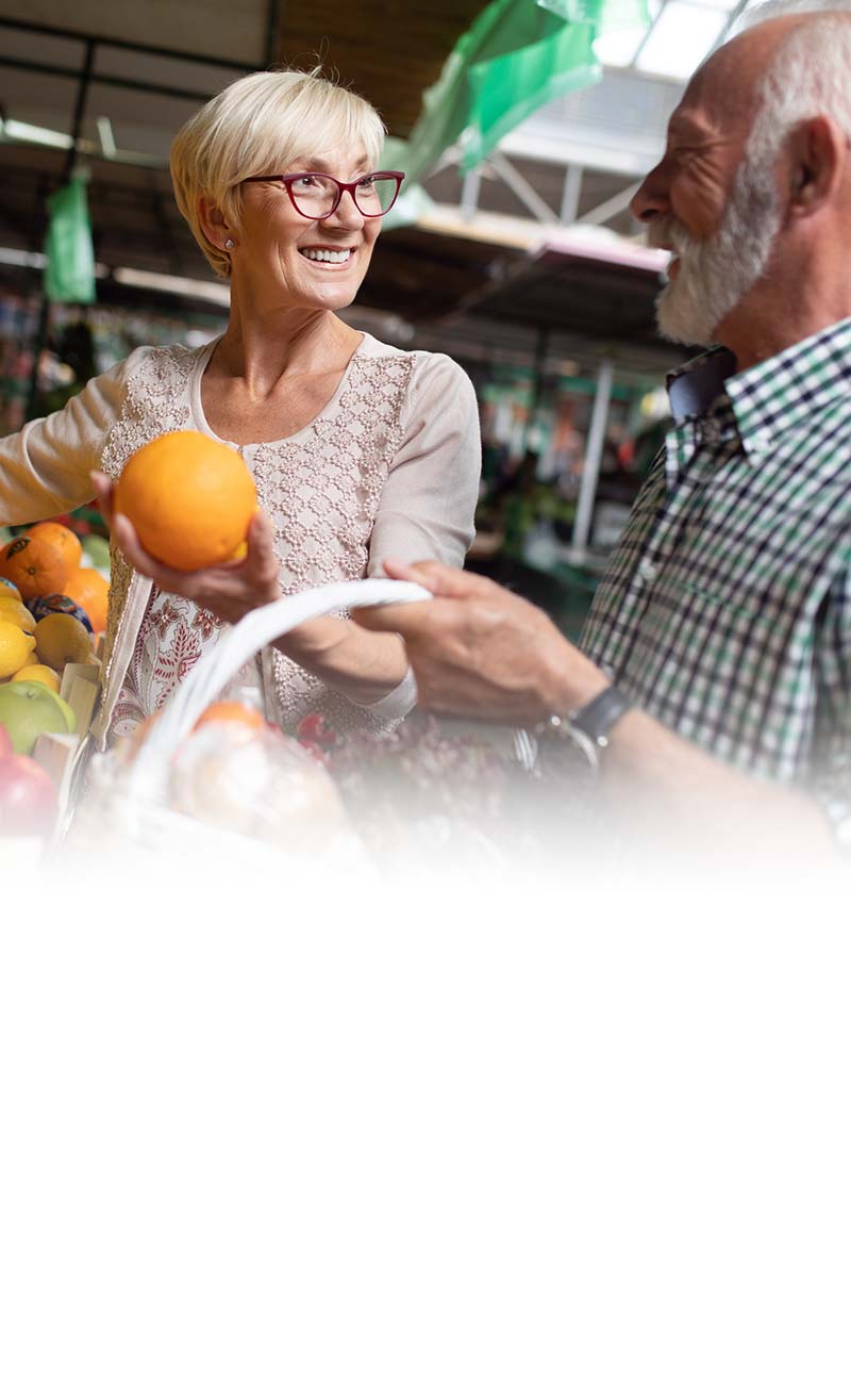 Senior couple shopping for fresh fruit at market
