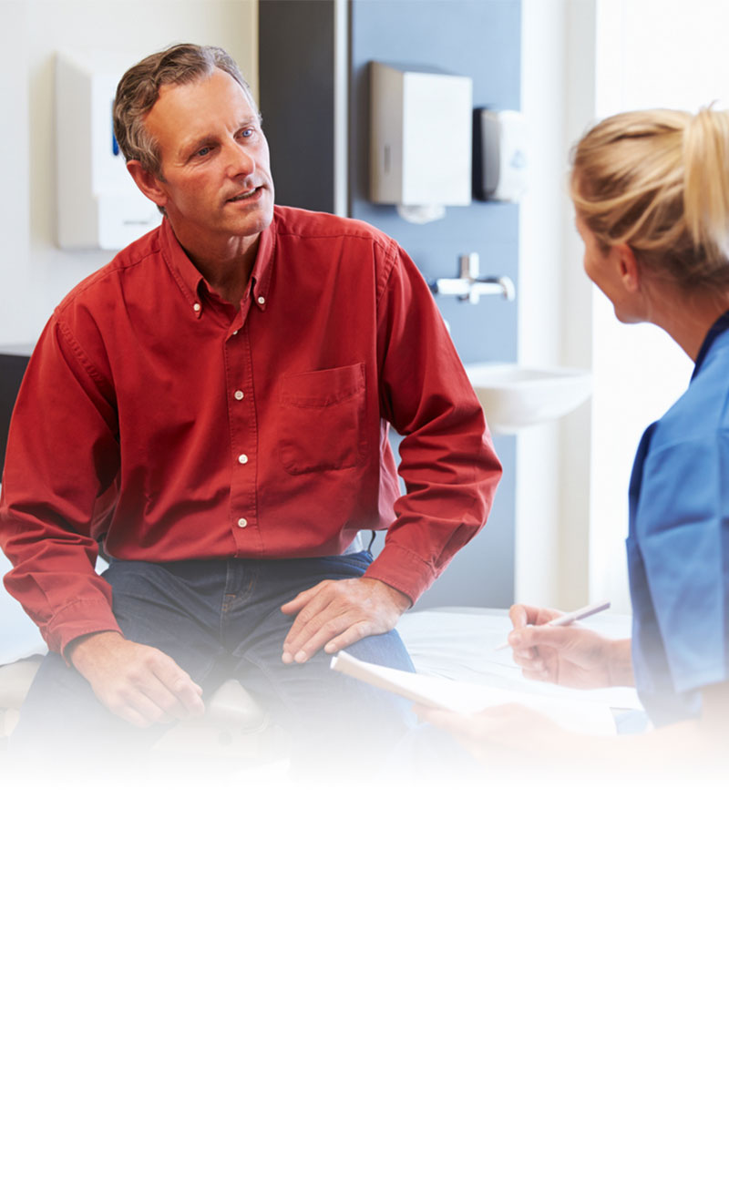 man talking with female clinician in exam room