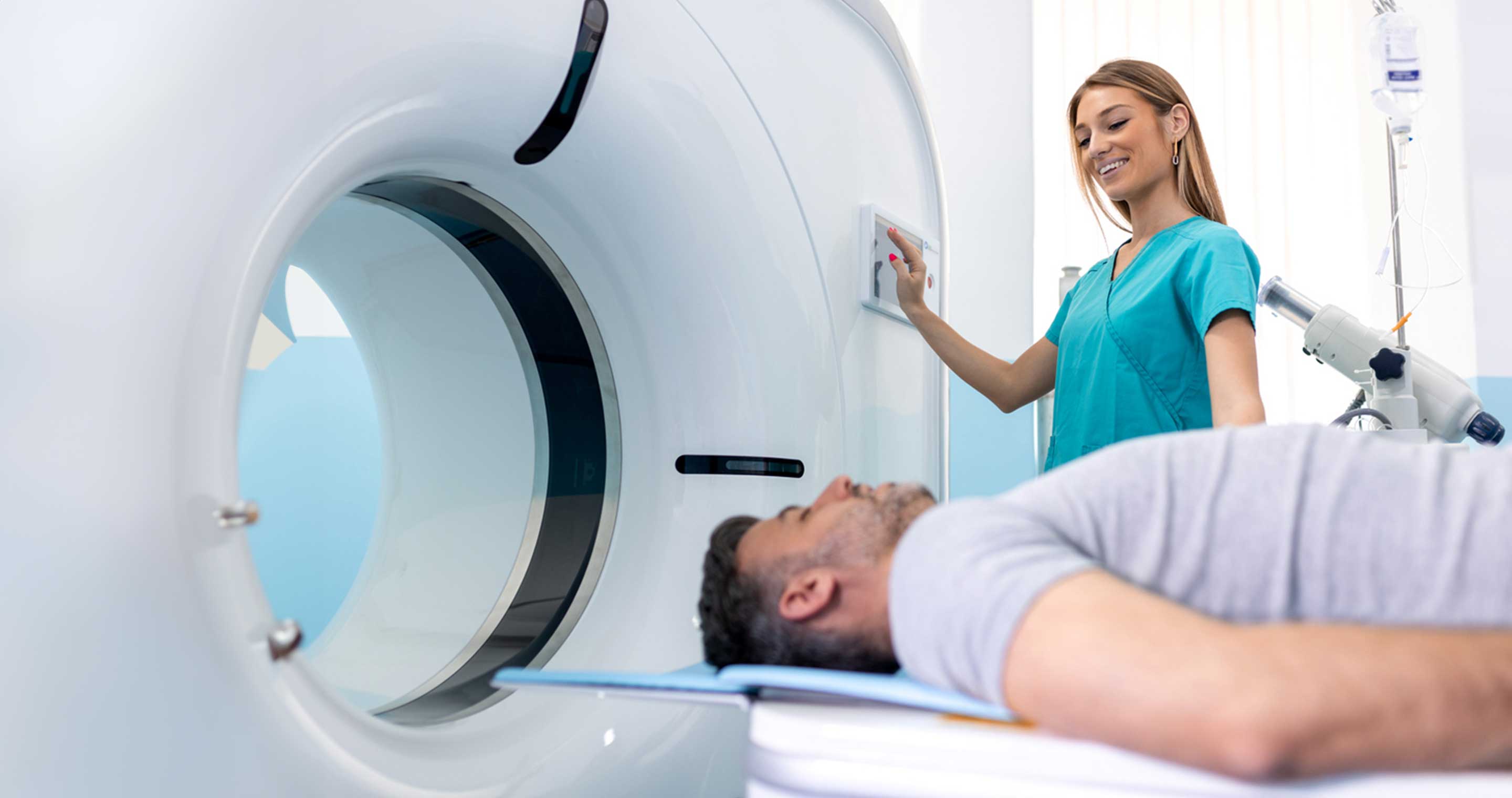 female clinician preparing a man for an MRI