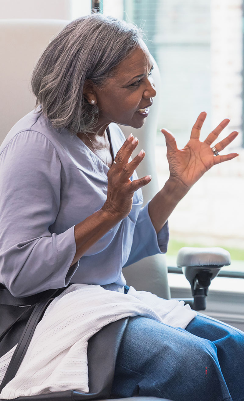 A woman talks animatedly with her doctor.
