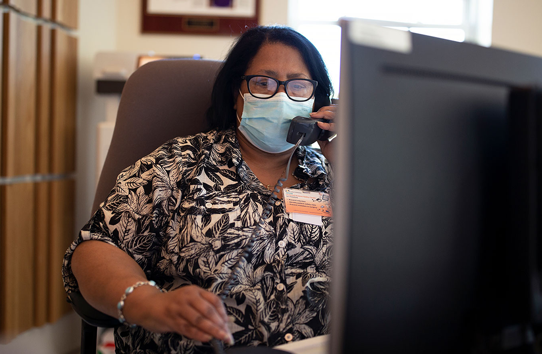 woman talking on phone in front of computer in reception area