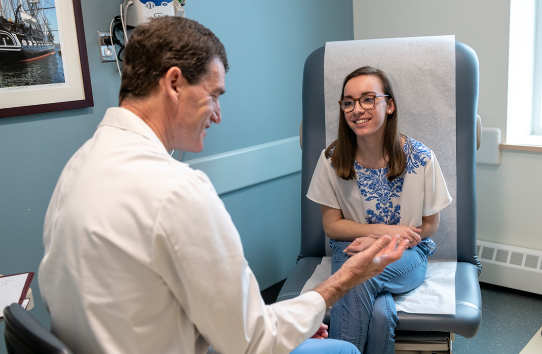 male provider with female patient in exam room