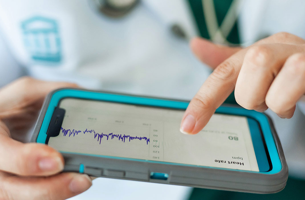 clinician monitoring patient's heart rate on a mobile device
