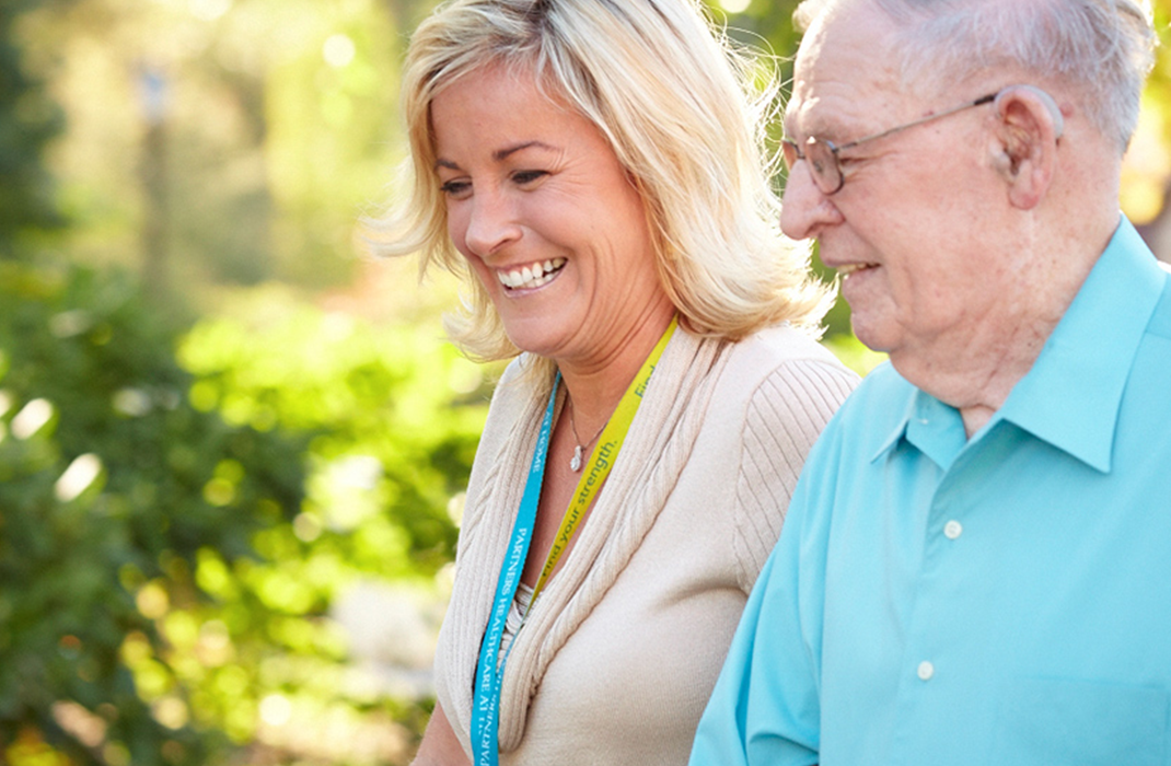 female provider walking with senior male outside