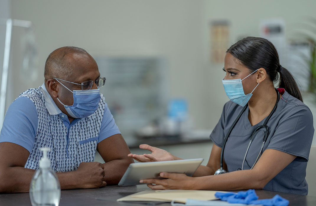 Masked provider talks to masked patient