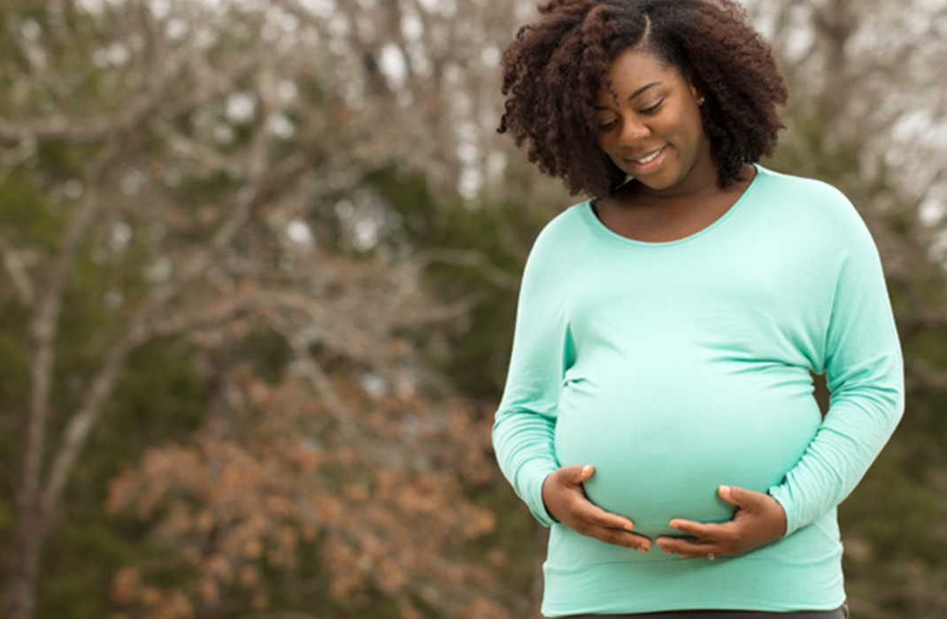 pregnant woman cradling her belly