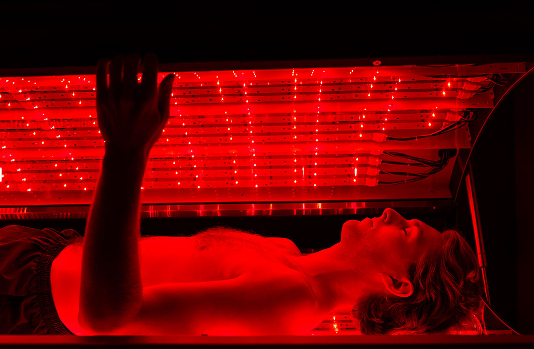 man laying down in red light therapy bed