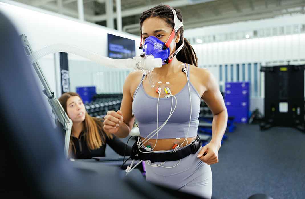 woman on treadmill with oxygen mask underoing a fitness assessment