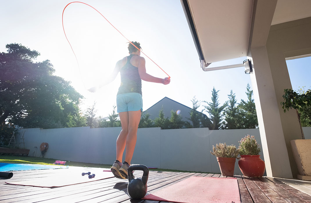 woman jumping rope outdoors on sunny day