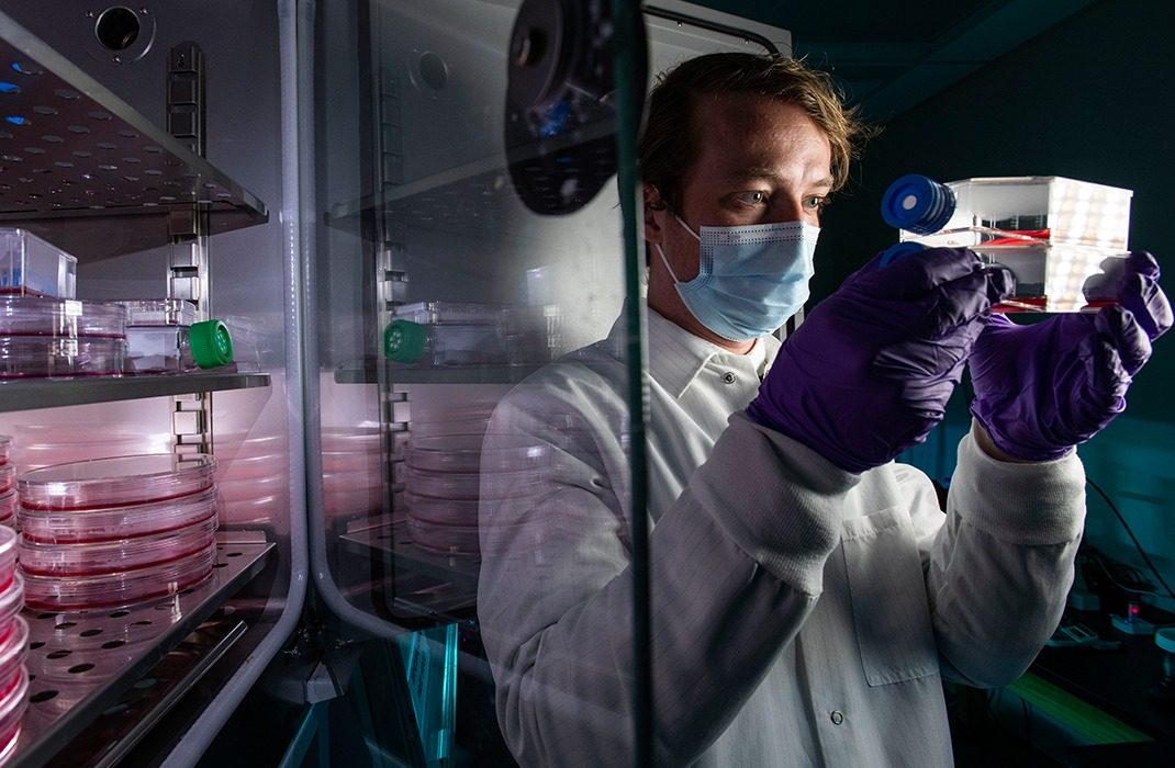 make researcher in lab holding a tray of samples