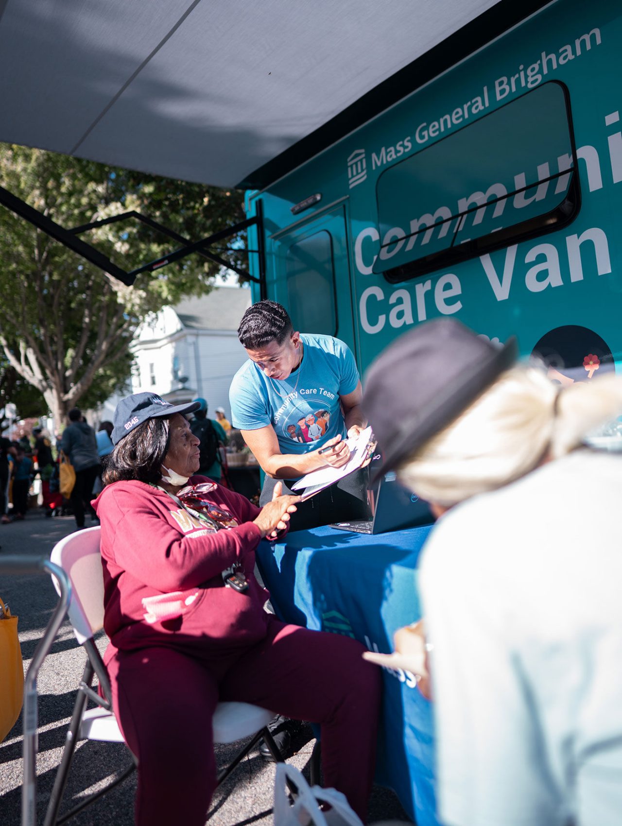 A community care team provider talks with a patient at an event