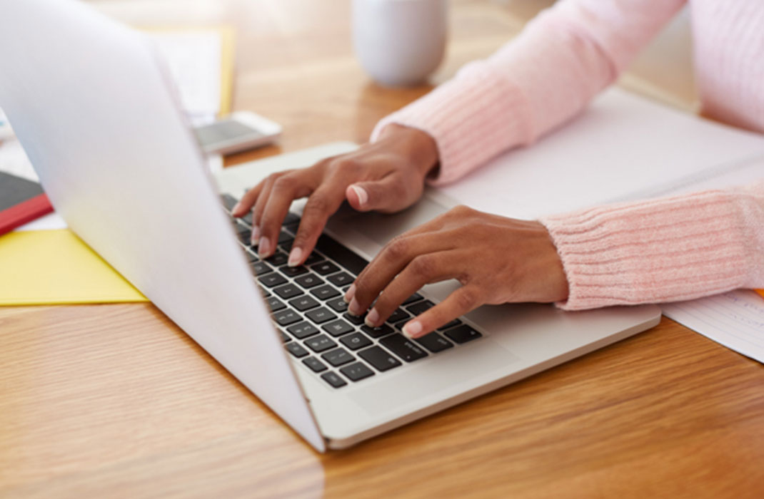 A person types on a laptop