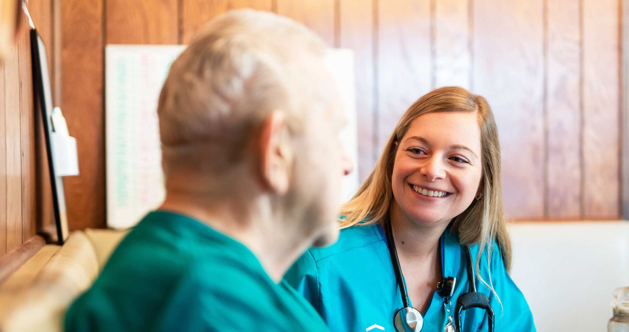 female medical provider speaking to senior male patient