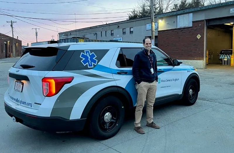 Mass General Brigham paramedic Derek Guanaga standing next to a medical vehicle