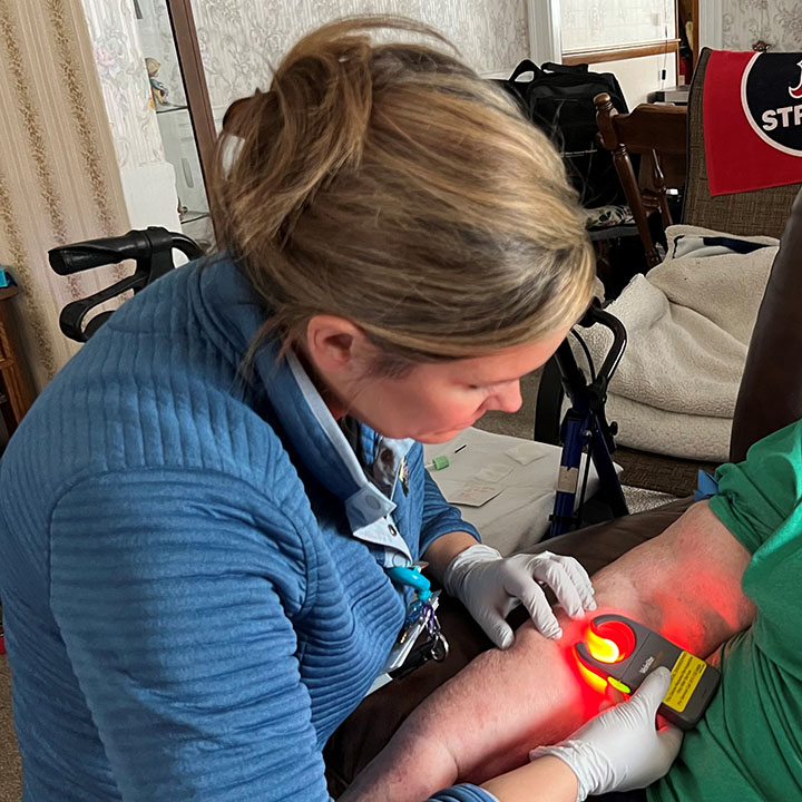 female paramedic taking patient vitals in their home