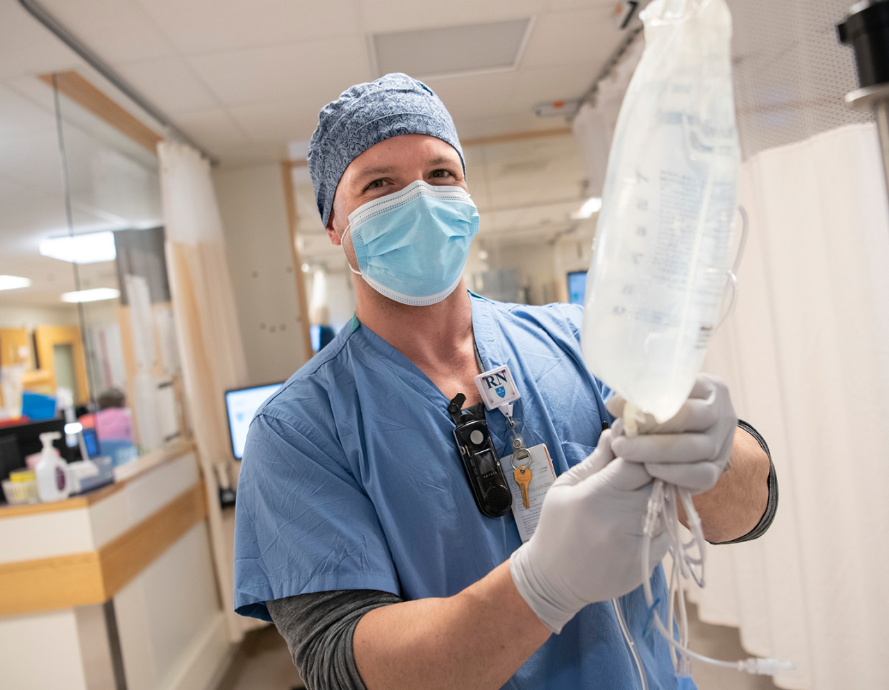 male nurse setting up IV fluid bag