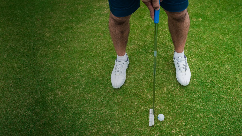 Man golfing on green grass