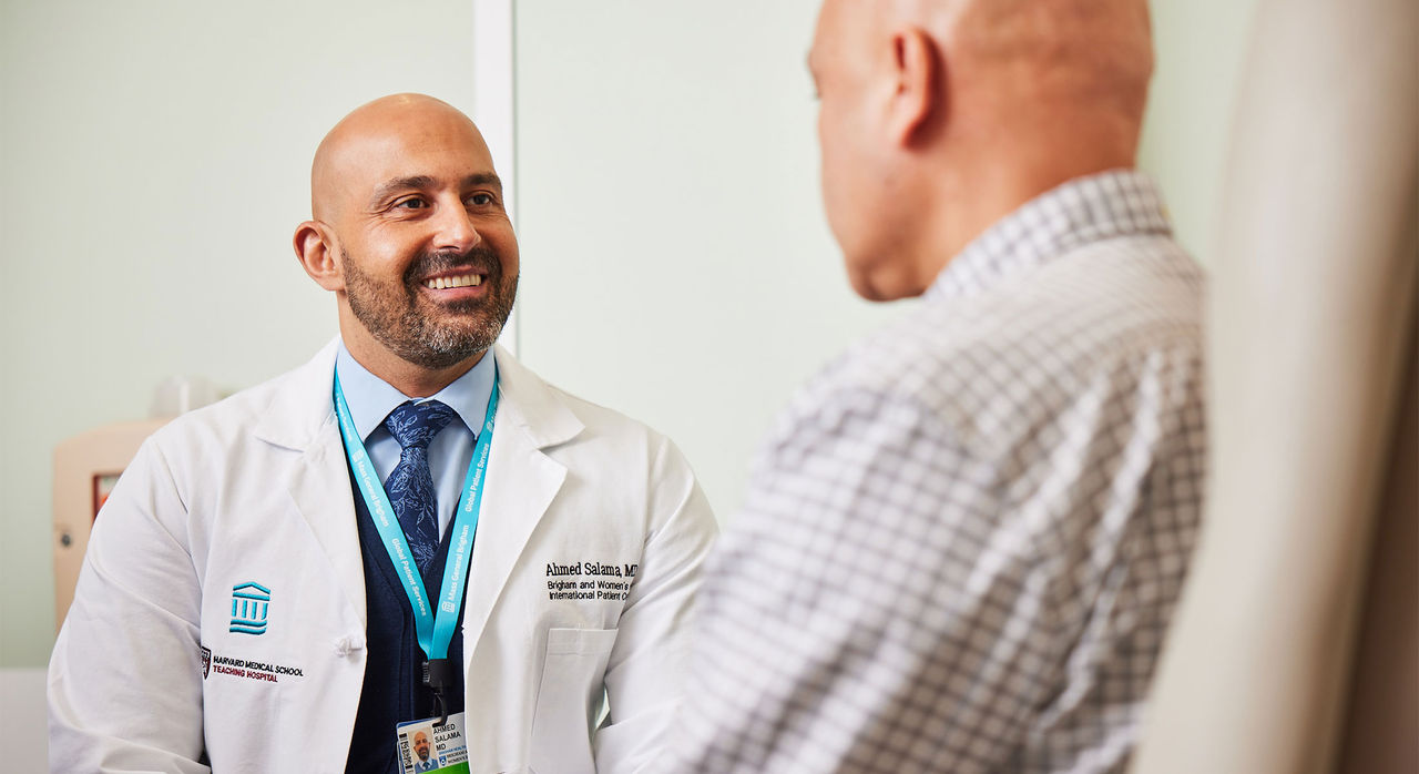 A doctor talks to a patient in an examining room.