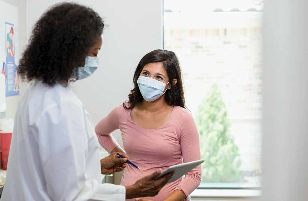 Doctor and patient wearing masks and talking