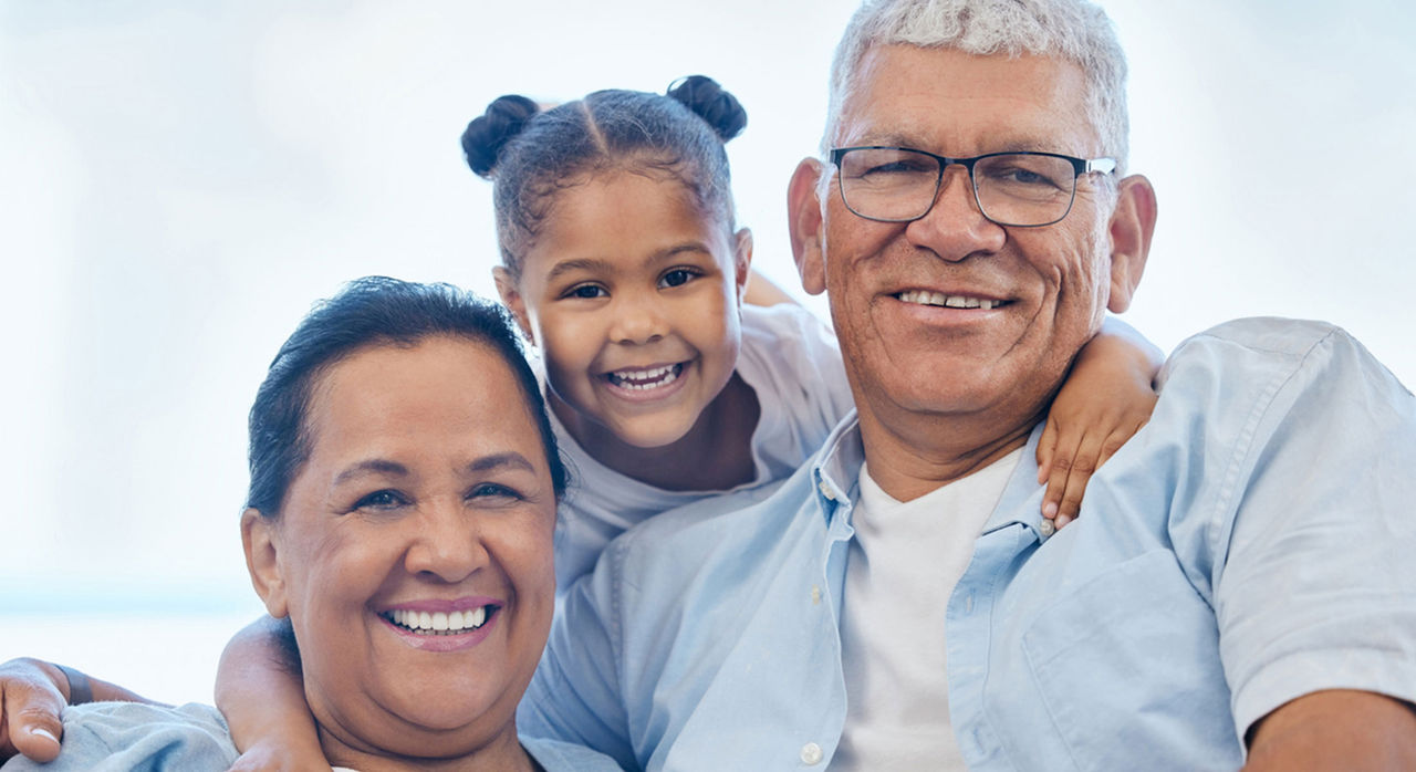 A woman, man, and child pose together, smiling