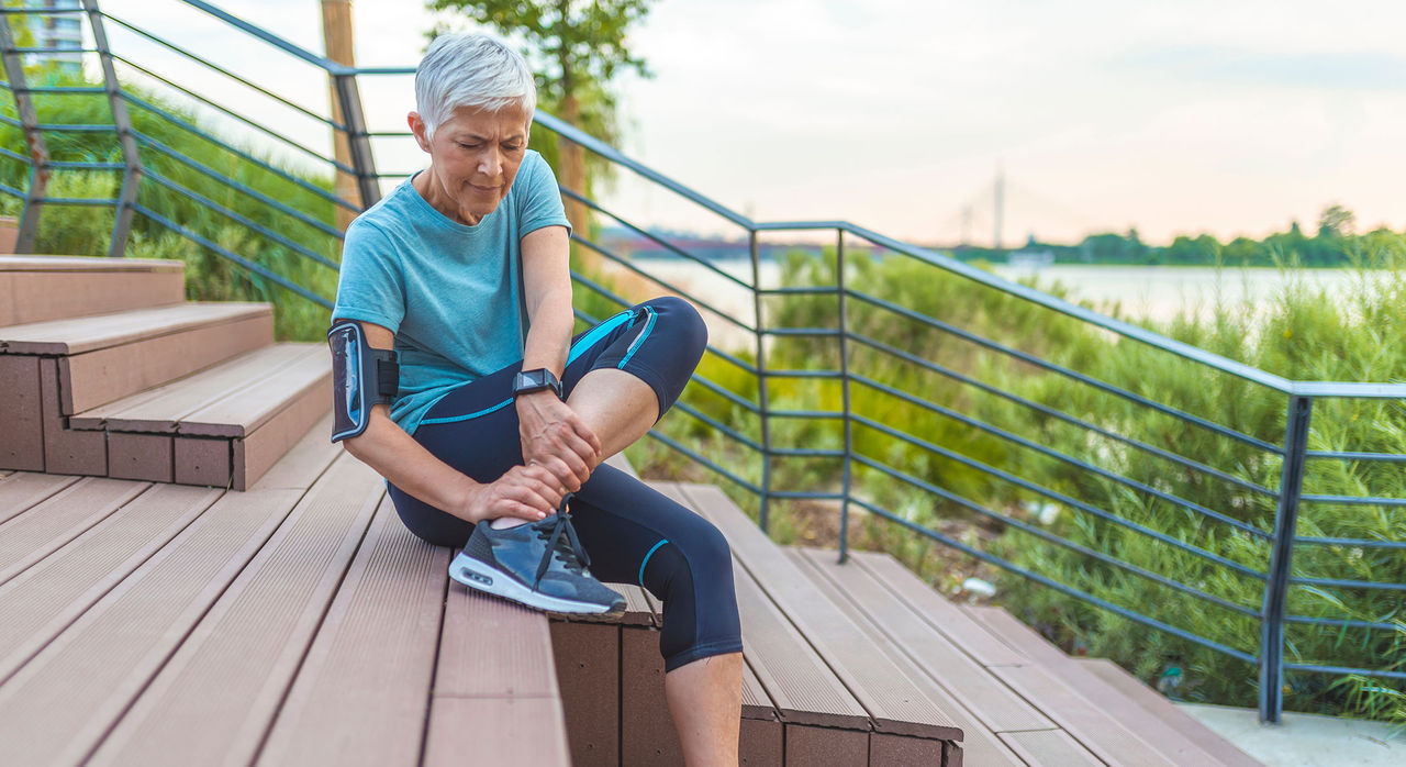 Woman touching her thigh because of pain. Running injury leg accident- sport woman runner hurting holding painful sprained ankle in pain. Female athlete runner touching foot in pain