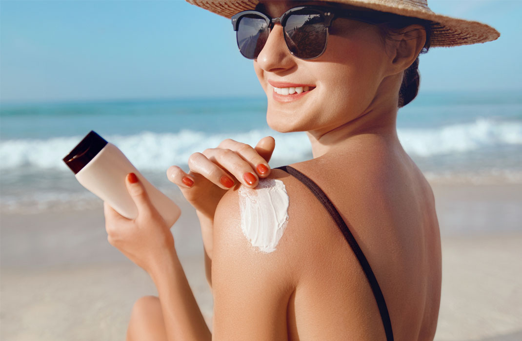 A woman with hat, sunglasses and sunscreen