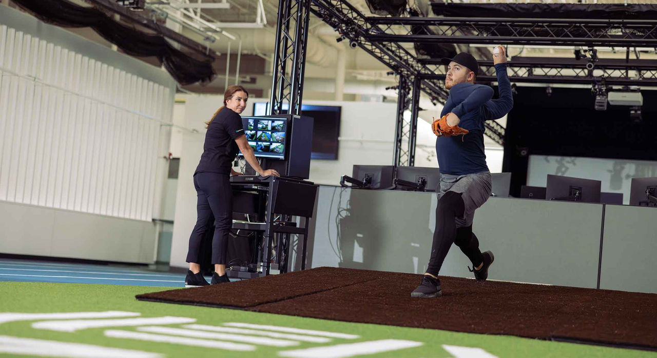 A baseball player practices pitching in the pitching lab.