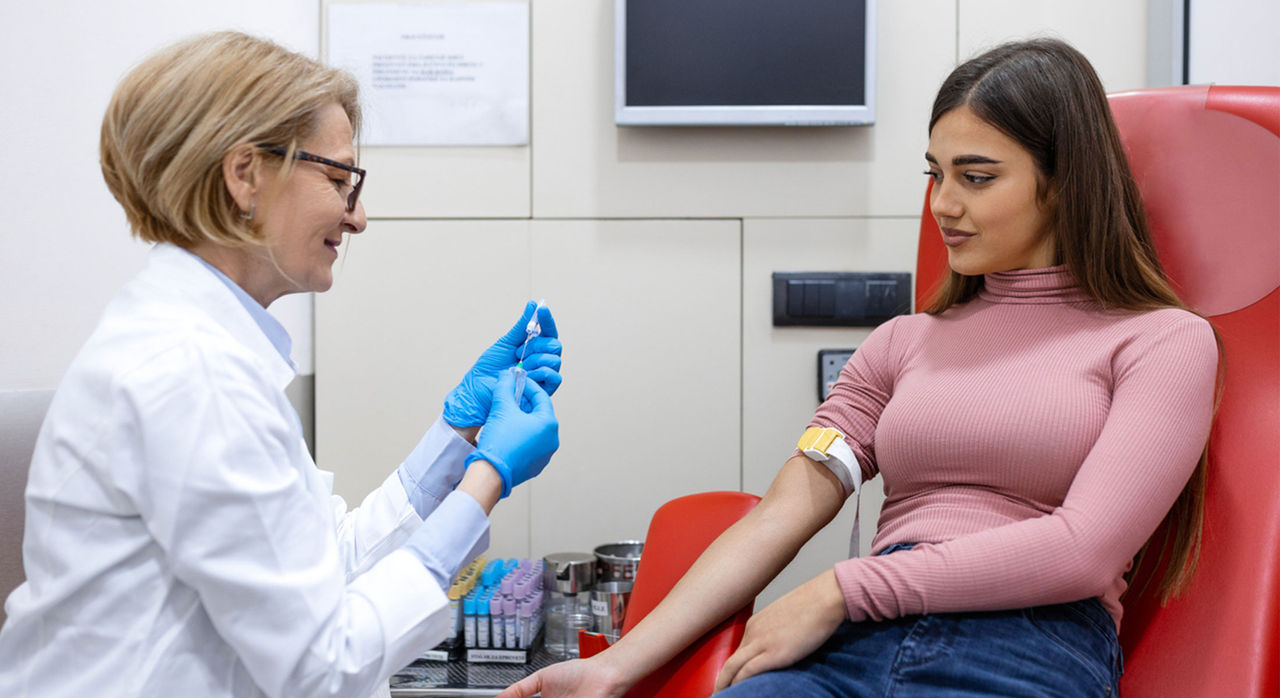 Young woman gets blood test for heart disease. Blood tests for hsCRP, LDL-C, and lipoprotein can predict heart disease.