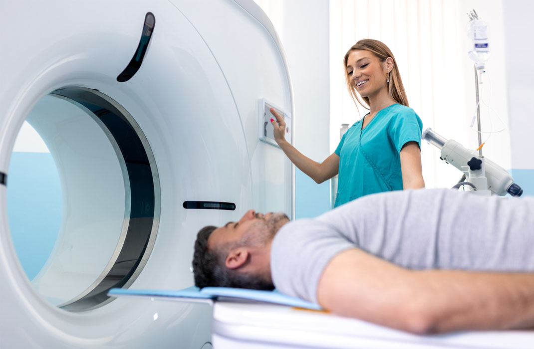 A provider prepares a patient for a CT scan for brain tumor screening.