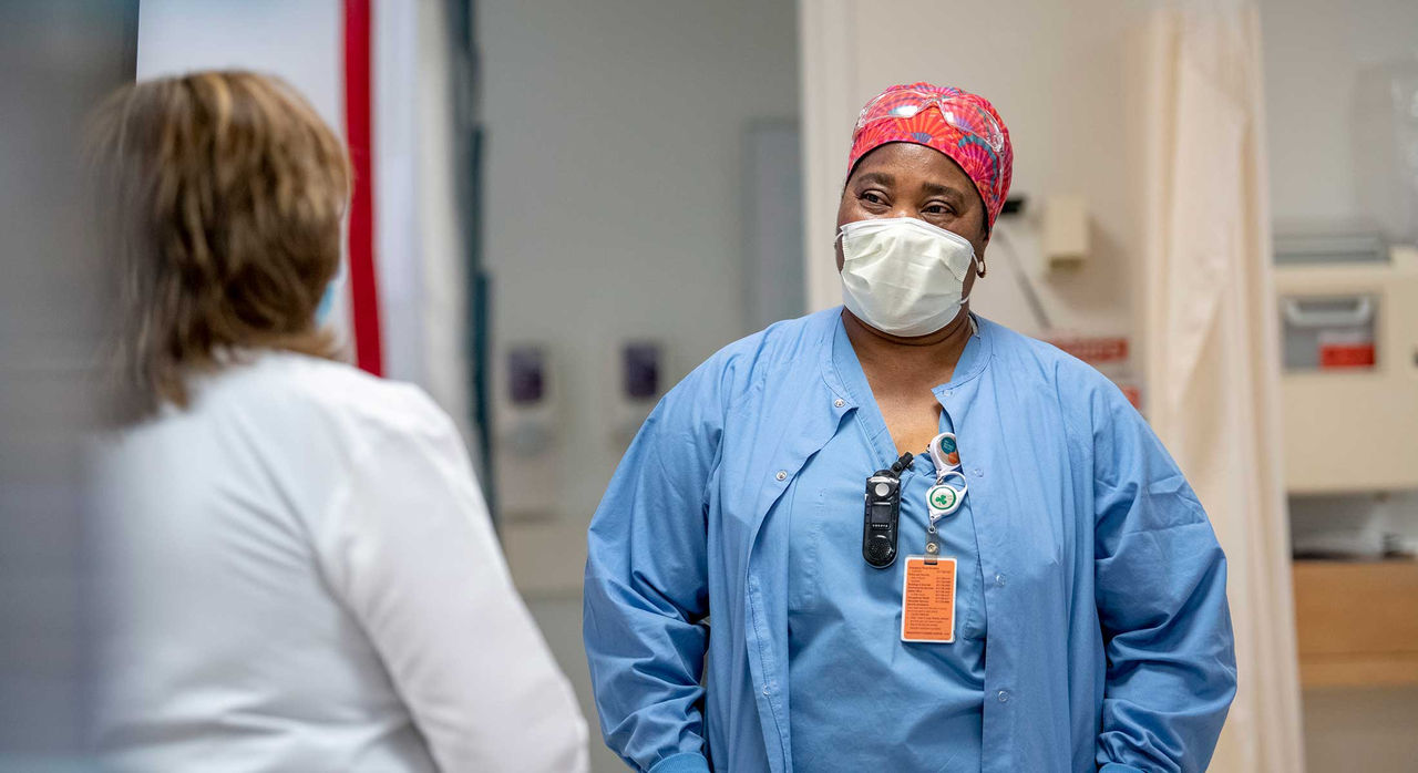 Two health care providers talking in an examination room.