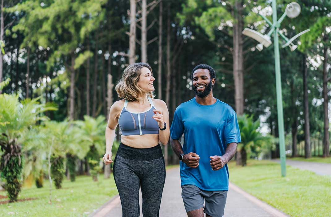 A man and woman walking briskly outdoors.