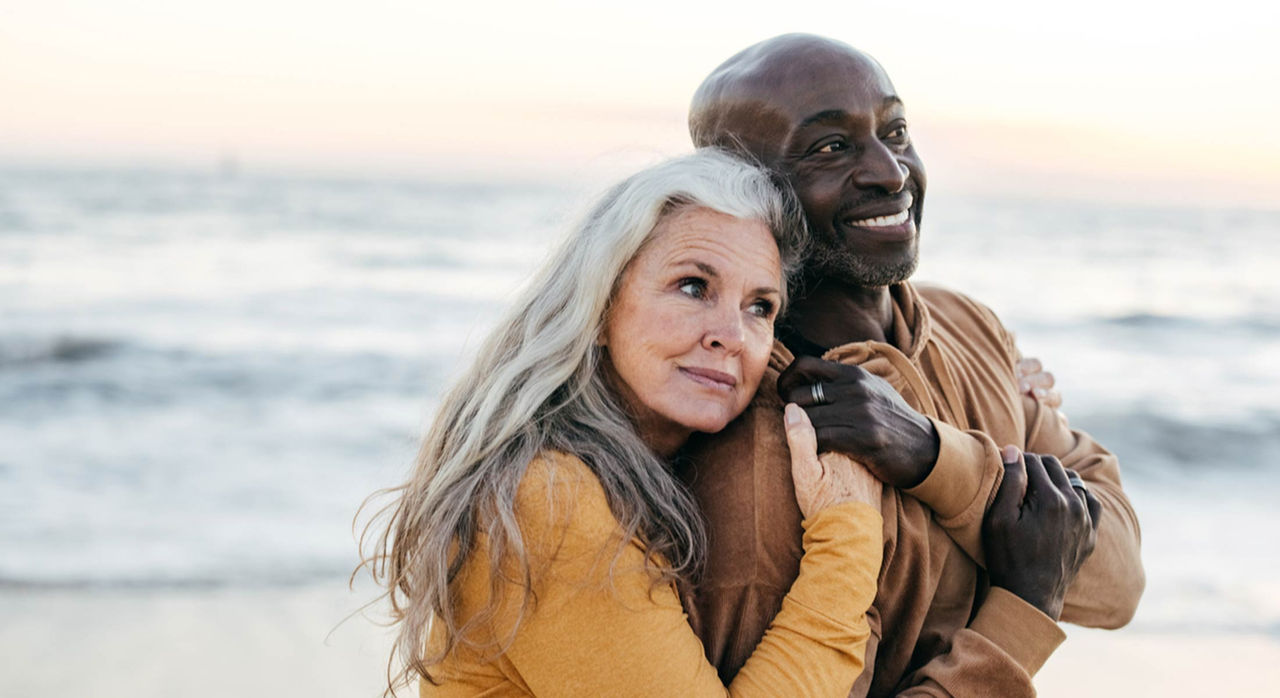 An older woman and man holding each other with hands locked together