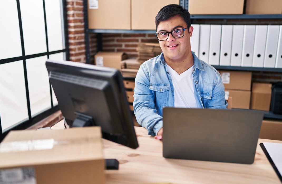A man with Down syndrome working on his laptop.