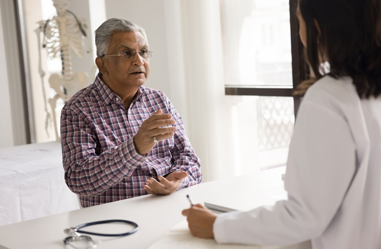 An elderly patient speaks with his doctor.