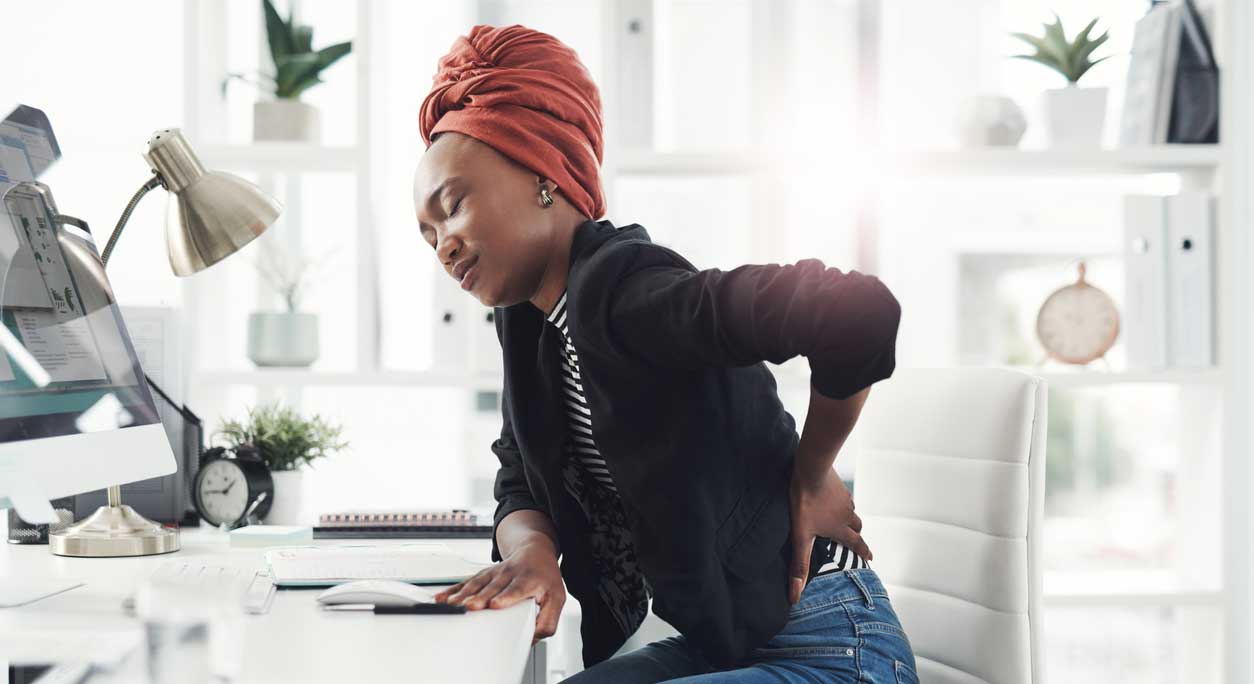 Woman with chronic back pain at desk