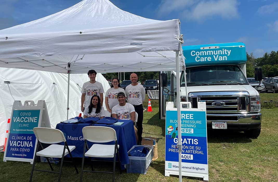 Volunteers pose in front of a Community Care Van at the Mashpee Wampanoag Powwow..