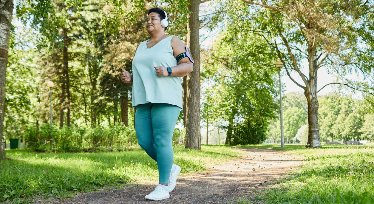 An older woman jogging in a park.
