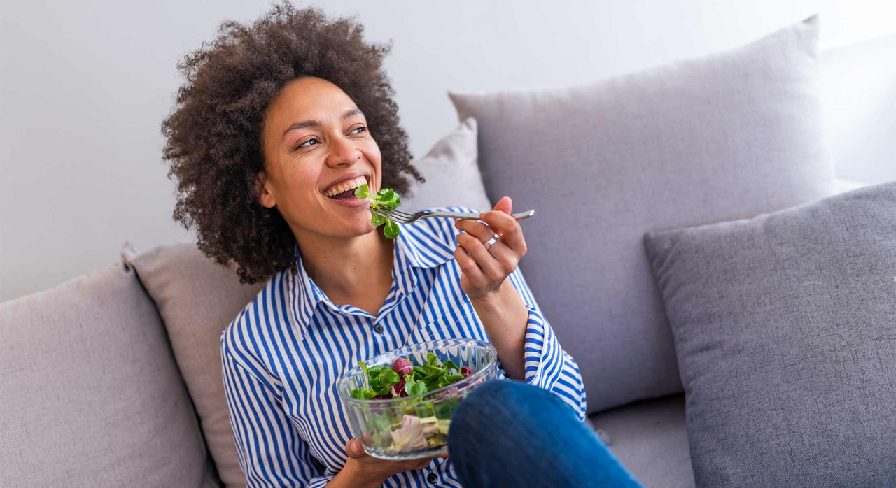 A woman eating salad during the day time