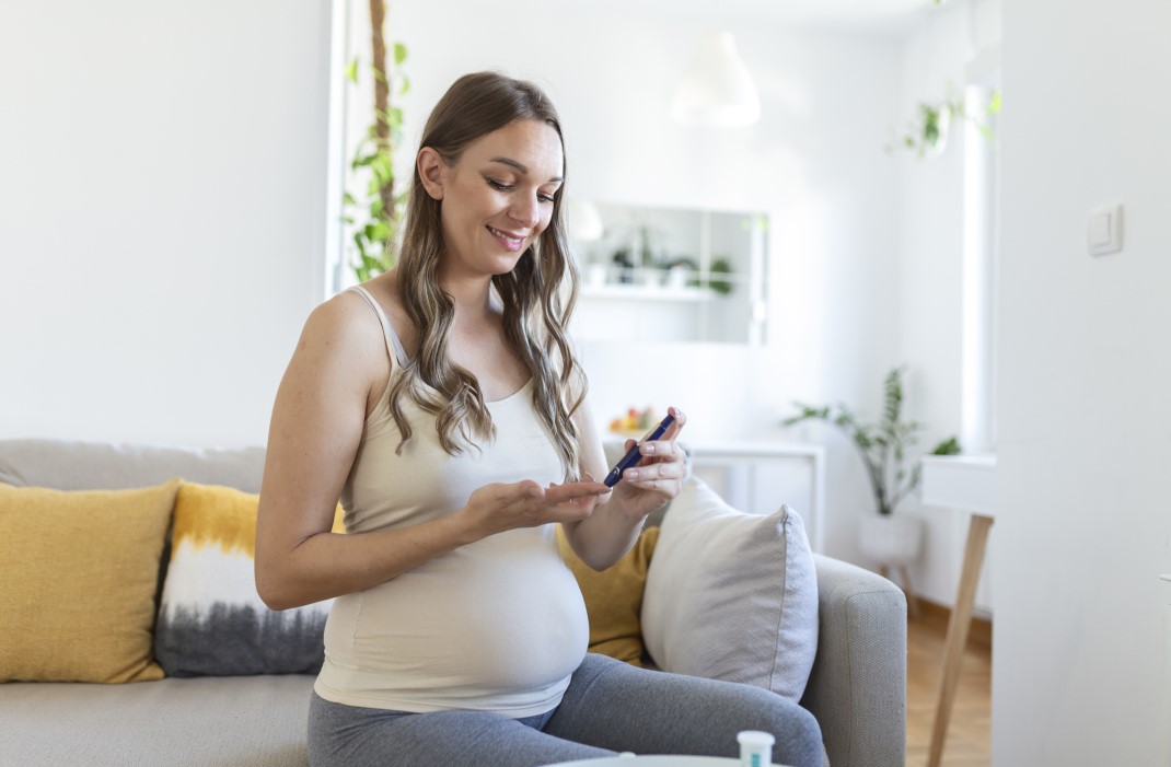 Pregnant woman with diabetes checks blood sugar.