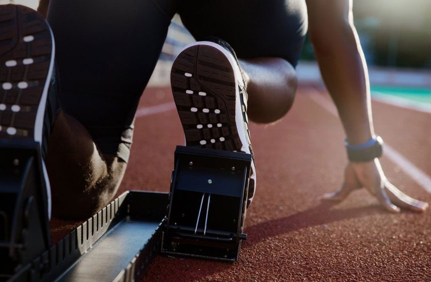 athlete crouching in the track blocks ready to sprint