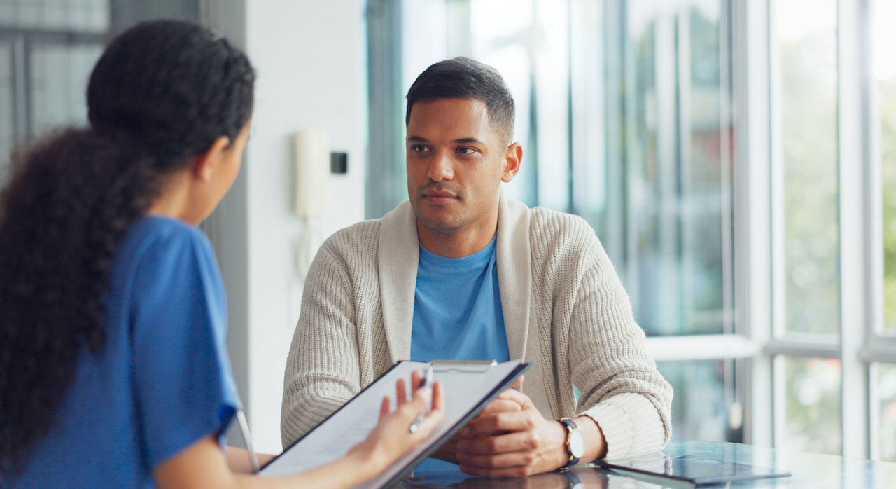 Adult with early signs of MS talking to nurse