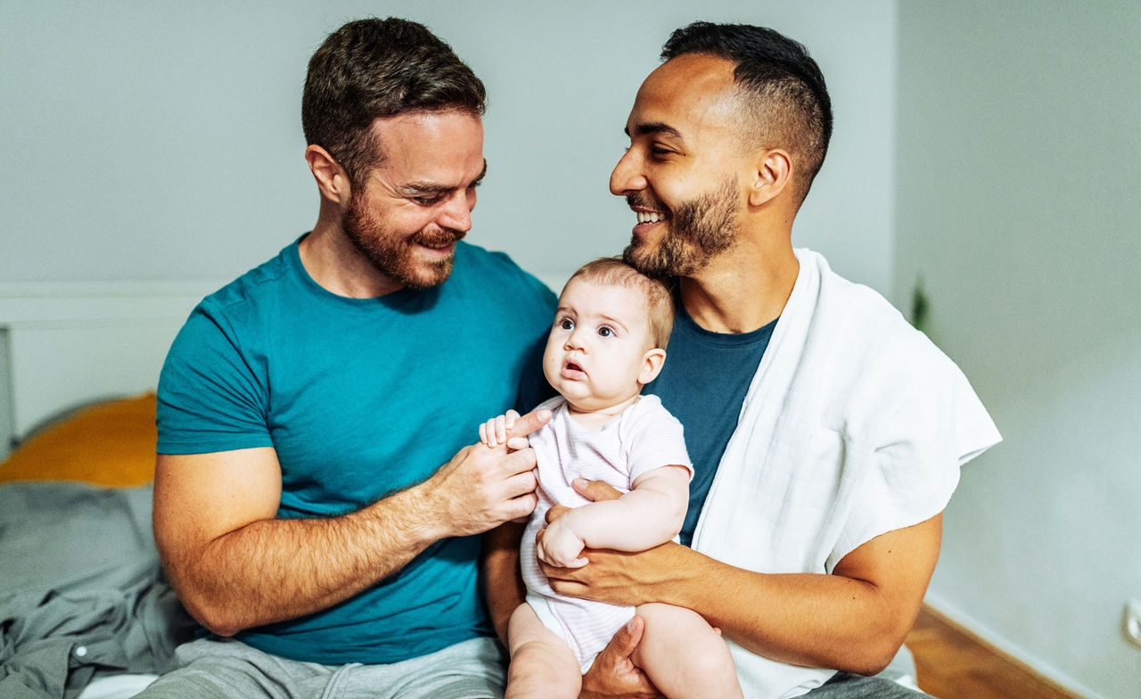 Gay couple holds baby conceived through surrogacy