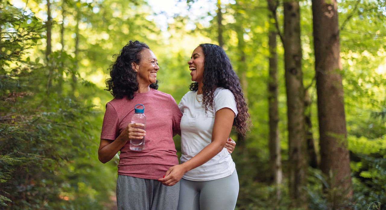 Two women laughing and enjoying a walk on a nature trail