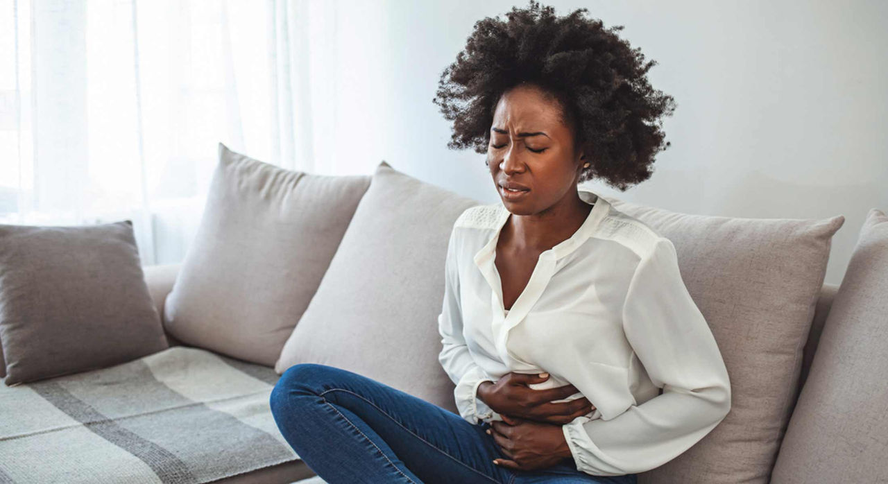 A woman at home suffers with endometriosis pain